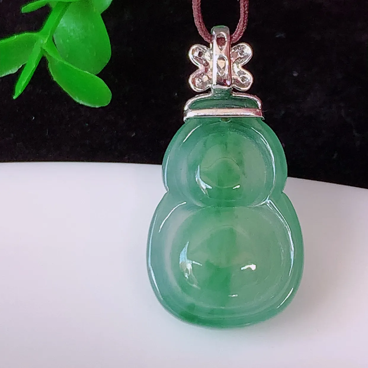 自然光实拍，18K金镶嵌冰种飘花翡翠葫芦吊坠，款式新颖，佩戴效果时尚出众，尽显气质，玉质细腻，美感十足。#00.9整体25*裸石18.5*12.8*5.2
