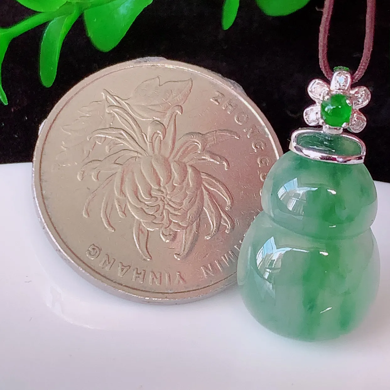 自然光实拍，18K金镶嵌冰种飘花翡翠葫芦吊坠，款式新颖，佩戴效果时尚出众，尽显气质，玉质细腻，美感十足。#00.9整体25*裸石18.5*12.8*5.2
