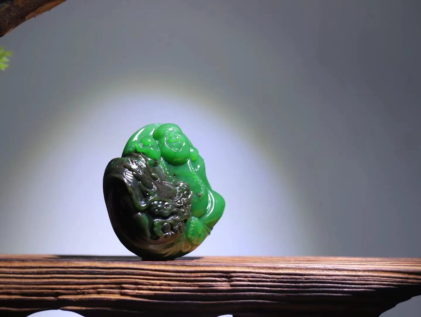 和田玉红皮碧玉佛公挂件文案
【色泽与质感】
温润的碧玉底色，盈润细腻，色泽浓而不艳，绿中透着生机与灵气。红皮部分犹如一抹朝霞，点缀其间，形成天然的色彩对比，更显尊贵与吉祥。
【寓意与象征】
佛公笑意盈盈，象征平安喜乐、福气满满；碧玉代表生命与活力，寓意健康长寿；红皮则是鸿运与喜庆的象征。三者相融，便是“福运常伴、健康平安”的美好祝愿。
规格：54-20mm克重：88g