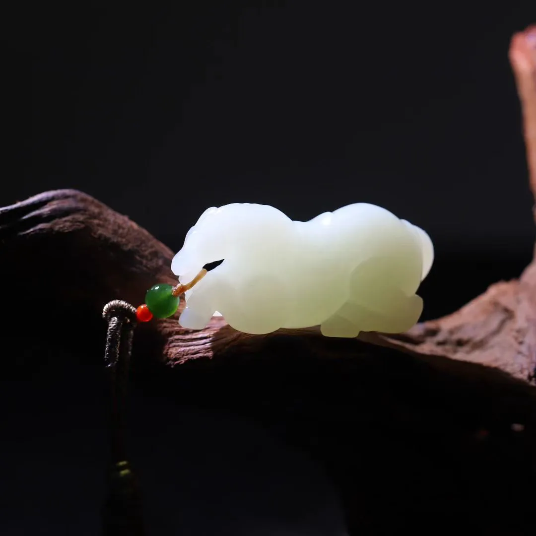 祥瑞臻品
【马~丰年载福】和田羊脂白玉精雕瑞马，玉质凝若羊脂膏腴，透光处泛起蜜蜡般柔晕。马身圆润如满月悬空，丰腴而不失矫健，鬃尾卷曲似祥云凝脂，四蹄敦实若莲台承露。肌骨线条浑圆流转，腹部饱满暗合聚财之相，回首凝眸时玉光温润生暖意，既可陈于案头作五谷丰登之景，亦能盈握掌心触福泽流转。
【规格】48-22-21mm,31.5g
