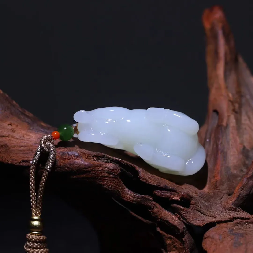 祥瑞臻品
【马~丰年载福】和田羊脂白玉精雕瑞马，玉质凝若羊脂膏腴，透光处泛起蜜蜡般柔晕。马身圆润如满月悬空，丰腴而不失矫健，鬃尾卷曲似祥云凝脂，四蹄敦实若莲台承露。肌骨线条浑圆流转，腹部饱满暗合聚财之相，回首凝眸时玉光温润生暖意，既可陈于案头作五谷丰登之景，亦能盈握掌心触福泽流转。
【规格】48-22-21mm,31.5g