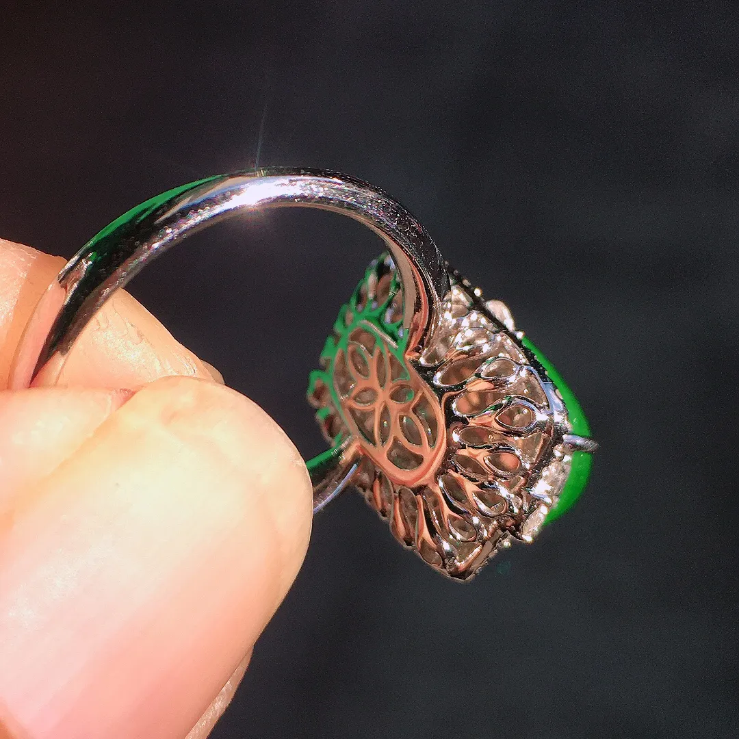 阳绿马鞍戒指，色泽均匀艳丽，玉质细腻，荧光感超
强，饱满圆润，尽显优雅气质，18k
金豪华镶嵌