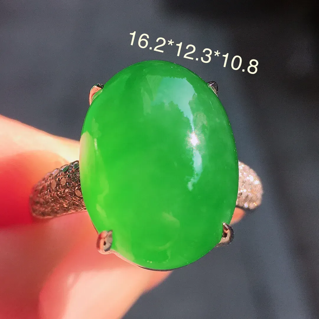 阳绿蛋面戒指，色泽均匀艳丽，玉质细腻，荧光感超
强，饱满圆润，尽显优雅气质，18k
金豪华镶嵌
