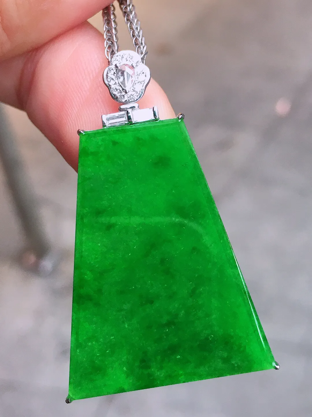 阳绿无事牌吊坠，色泽均匀艳丽，玉质细腻，荧光感超
强，饱满圆润，尽显优雅气质，18k
金豪华镶嵌