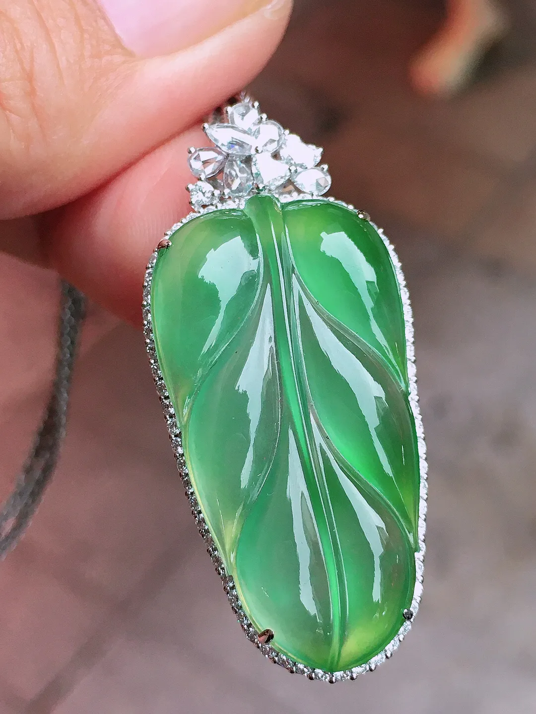 冰绿玉叶吊坠，色泽均匀艳丽，玉质细腻，荧光感超
强，饱满圆润，尽显优雅气质，18k
金豪华镶嵌