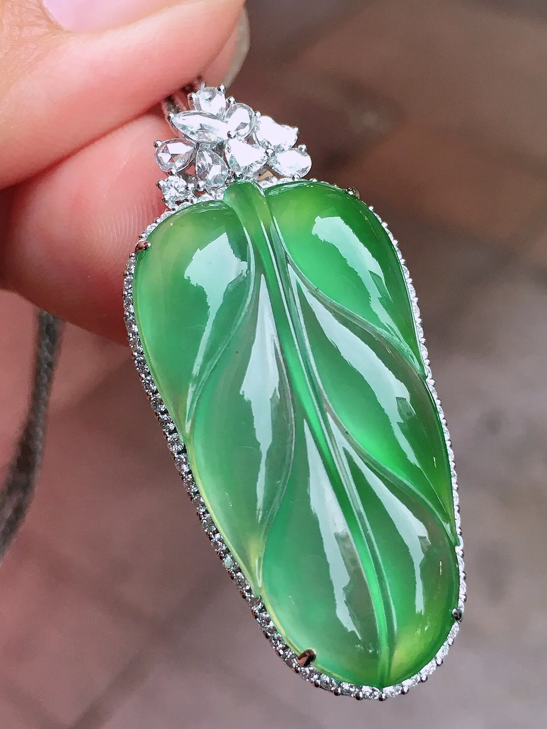 冰绿玉叶吊坠，色泽均匀艳丽，玉质细腻，荧光感超
强，饱满圆润，尽显优雅气质，18k
金豪华镶嵌