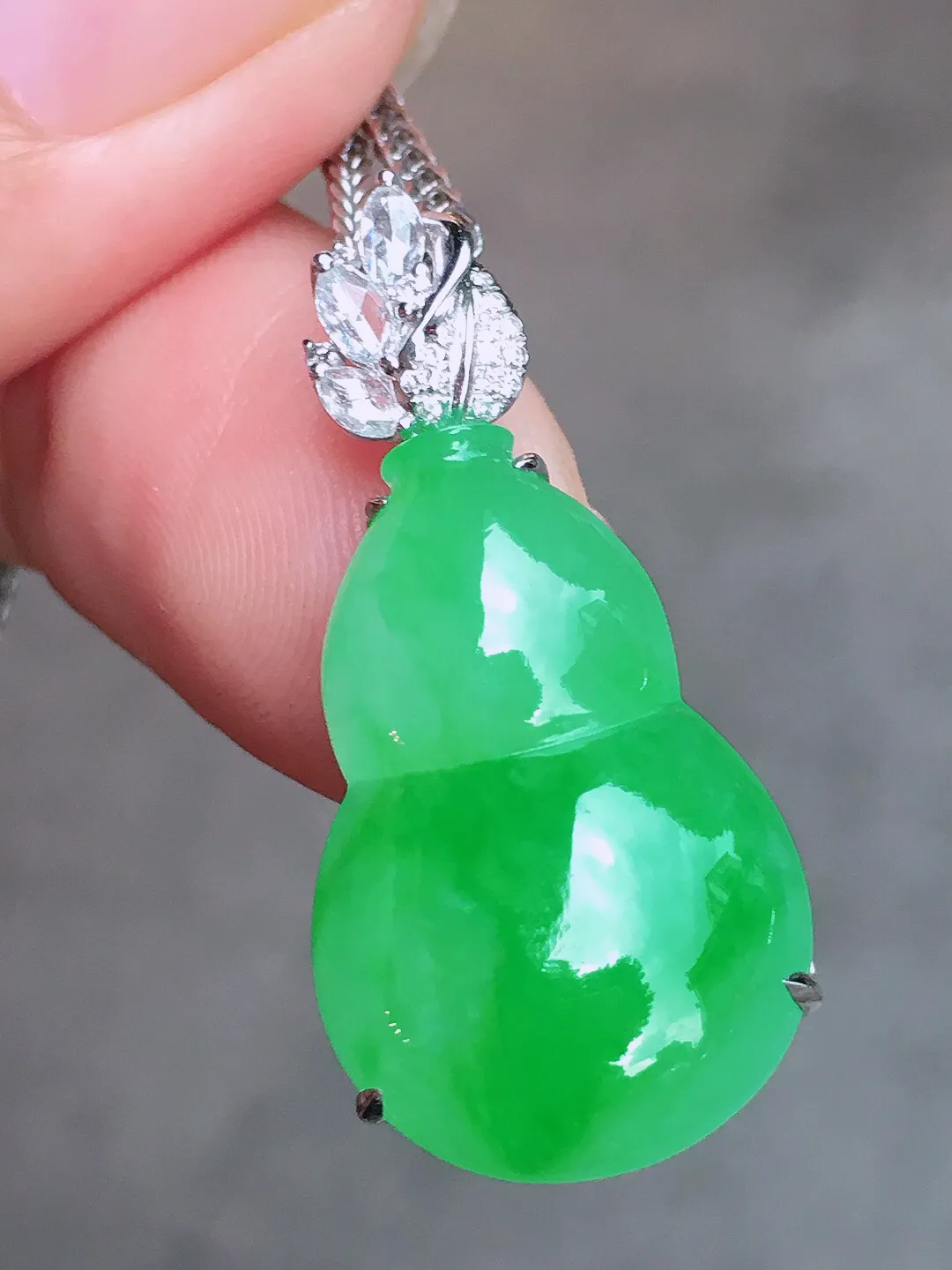 阳绿葫芦吊坠，色泽均匀艳丽，玉质细腻，荧光感超
强，饱满圆润，尽显优雅气质，18k
金豪华镶嵌