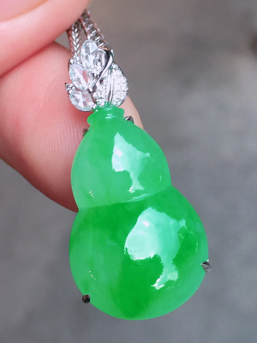 阳绿葫芦吊坠，色泽均匀艳丽，玉质细腻，荧光感超
强，饱满圆润，尽显优雅气质，18k
金豪华镶嵌