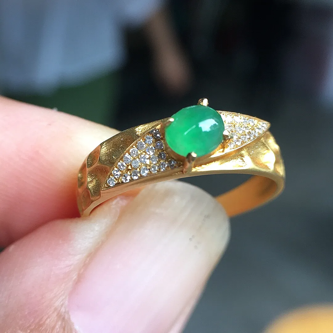冰绿蛋面戒指，色泽均匀艳丽，玉质细腻，荧光感超
强，饱满圆润，尽显优雅气质，18k
金豪华镶嵌