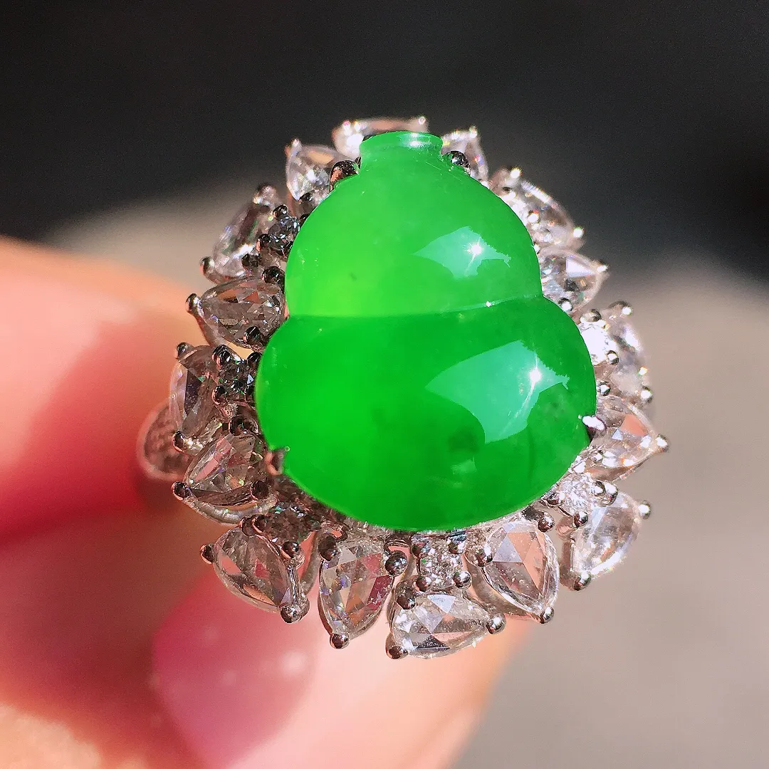 阳绿葫芦戒指，色泽均匀艳丽，玉质细腻，荧光感超
强，饱满圆润，尽显优雅气质，18k
金豪华镶嵌