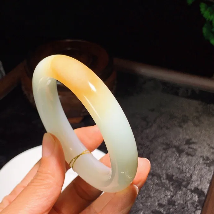 59圈口。新疆和田玉且末糖羊脂白玉手镯。且末糖一口糖手镯。圈口59条宽14厚10重72克。玉质细腻油润。无裂无杂。手推出油。品相大气。 lt251013
