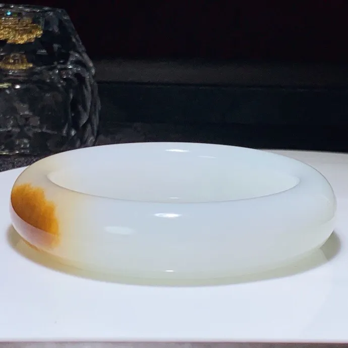 55圈口。新疆和田玉且末糖羊脂白玉手镯。且末糖一口糖手镯。圈口55条宽16厚11重81克。白度一级。玉质细腻油润。无裂无杂。手推出油。品相大气。 lt251013
