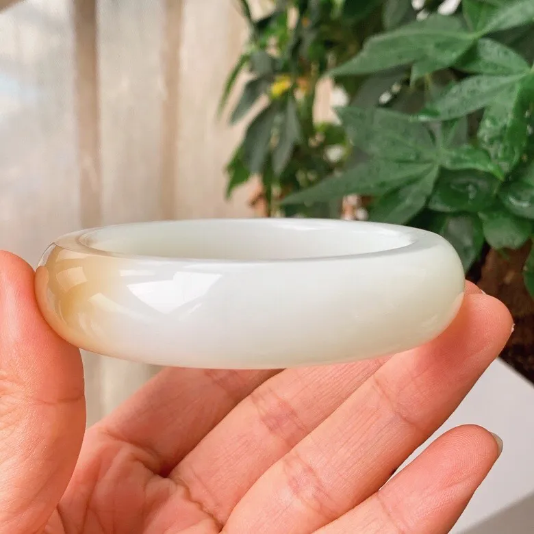 59圈口。新疆和田玉且末糖羊脂白玉手镯。且末糖一口糖手镯。圈口59条宽17厚10重89.9克。白度一