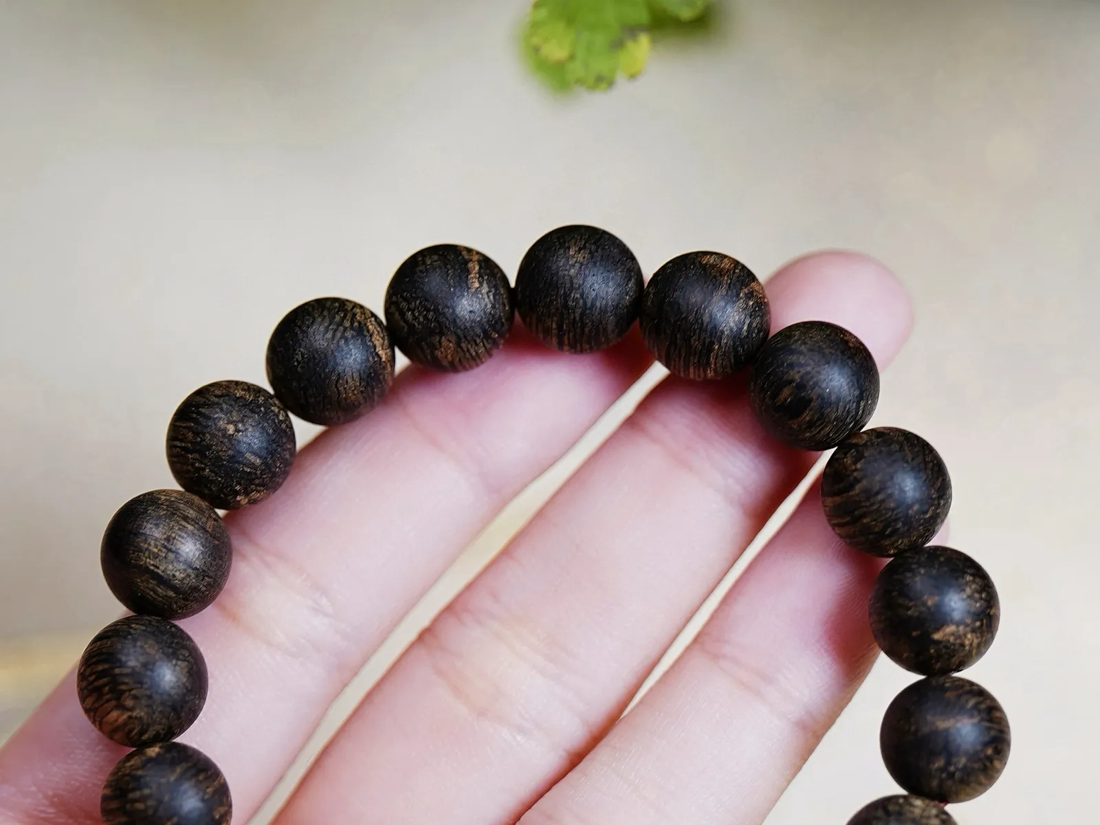 【文莱软丝黑棋·沉水 10mm】11.6 克

软丝油脂如膏似脂，在光下泛着乌润的光泽，指尖划过，是触得到的岁月温软，沉水的致密感握在掌心，每一寸都藏着结香的艰辛与珍贵，油线如墨玉流转，每一颗珠子的纹路都是自然独笔，是岁月沉淀的勋章，是自然用千年时光淬炼的香中舍利。
初闻，凉感如微风拂面，清灵的兰花香如幽谷绽放，带着几分雅致，转瞬，蜜甜感涌来，像刚凝成的花蜜，纯粹温润，细品间，又有淡淡的果香，软丝的特质让香气更显绵柔，沉水料的醇厚底气加持，佩戴温度稍升，香气便带着爆发力漫开，尾调竟浮起一丝清润奶韵，与兰香的柔，蜜甜的醇、果香的润，交织融合，层次分明却又浑然一体，丝丝缕缕织成一张让人沉溺的香网，每一次抬手，都是一场私藏的嗅觉盛宴。
这串手串，集齐了软丝的柔、沉水的厚、黑棋的贵，不愧为“星洲小奇楠”之称，是沉香收藏里可遇不可求的“王炸组合”。
这般珍品，本就稀若星芒，它不是普通的手串，是文莱沉香基因的浓缩，是能陪岁月慢慢沉淀的传家之味，戴在腕间，是随身的香氛秘境，藏于匣中，是岁月也偷不走的沉香顶流。