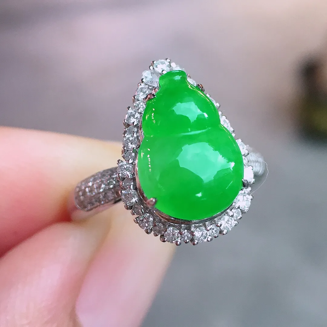 阳绿葫芦戒指，色泽均匀艳丽，玉质细腻，荧光感超
强，饱满圆润，尽显优雅气质，18k
金豪华镶嵌