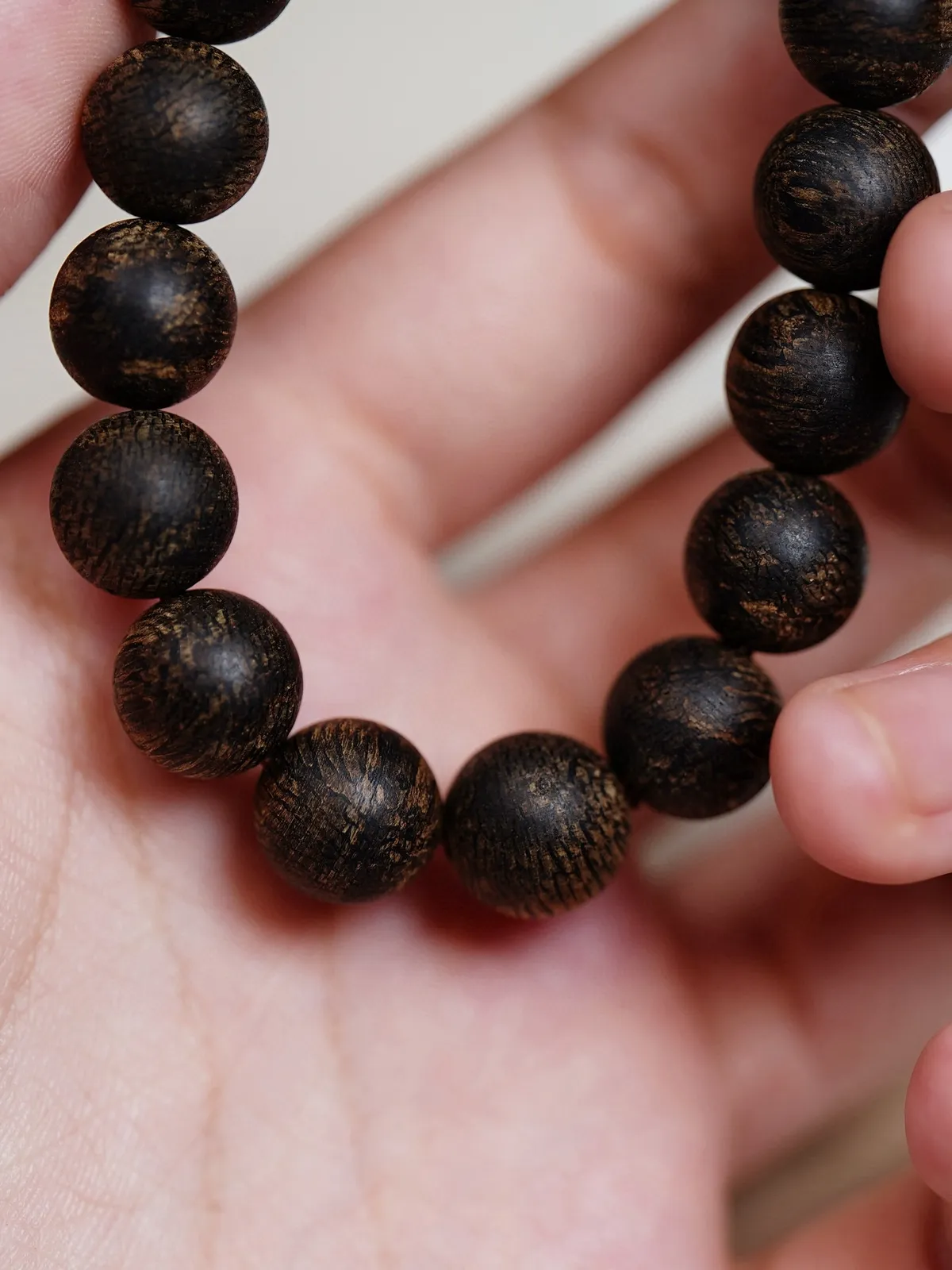 【文莱软丝黑棋·沉水 10mm】11.6 克

软丝油脂如膏似脂，在光下泛着乌润的光泽，指尖划过，是触得到的岁月温软，沉水的致密感握在掌心，每一寸都藏着结香的艰辛与珍贵，油线如墨玉流转，每一颗珠子的纹路都是自然独笔，是岁月沉淀的勋章，是自然用千年时光淬炼的香中舍利。
初闻，凉感如微风拂面，清灵的兰花香如幽谷绽放，带着几分雅致，转瞬，蜜甜感涌来，像刚凝成的花蜜，纯粹温润，细品间，又有淡淡的果香，软丝的特质让香气更显绵柔，沉水料的醇厚底气加持，佩戴温度稍升，香气便带着爆发力漫开，尾调竟浮起一丝清润奶韵，与兰香的柔，蜜甜的醇、果香的润，交织融合，层次分明却又浑然一体，丝丝缕缕织成一张让人沉溺的香网，每一次抬手，都是一场私藏的嗅觉盛宴。
这串手串，集齐了软丝的柔、沉水的厚、黑棋的贵，不愧为“星洲小奇楠”之称，是沉香收藏里可遇不可求的“王炸组合”。
这般珍品，本就稀若星芒，它不是普通的手串，是文莱沉香基因的浓缩，是能陪岁月慢慢沉淀的传家之味，戴在腕间，是随身的香氛秘境，藏于匣中，是岁月也偷不走的沉香顶流。