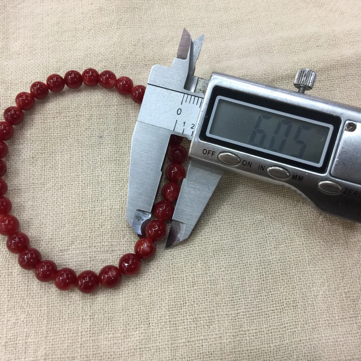 【天然日本阿卡红珊瑚6mm圆珠弹力单手串】难得高瓷度，日本产地，阿卡材料，整条少虫眼少白芯的阿卡圆珠。整条赤血牛血红颜色，珠子直径6.05-5.35mm，每颗珠子均为天然的珊瑚，珊瑚自古就为佛教珍宝，深海千年有机宝石！收藏价值高、可传承重量为7.75克！追求品质者的福音！实物漂亮！