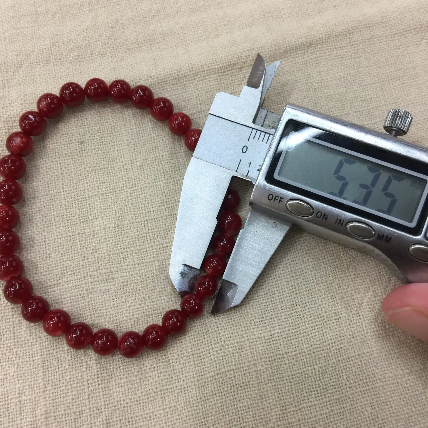 【天然日本阿卡红珊瑚6mm圆珠弹力单手串】难得高瓷度，日本产地，阿卡材料，整条少虫眼少白芯的阿卡圆珠。整条赤血牛血红颜色，珠子直径6.05-5.35mm，每颗珠子均为天然的珊瑚，珊瑚自古就为佛教珍宝，深海千年有机宝石！收藏价值高、可传承重量为7.75克！追求品质者的福音！实物漂亮！
