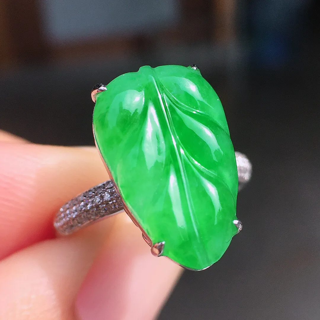 阳绿玉叶戒指，色泽均匀艳丽，玉质细腻，荧光感超
强，饱满圆润，尽显优雅气质，18k
金豪华镶嵌