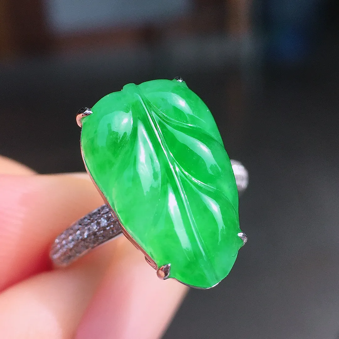 阳绿玉叶戒指，色泽均匀艳丽，玉质细腻，荧光感超
强，饱满圆润，尽显优雅气质，18k
金豪华镶嵌