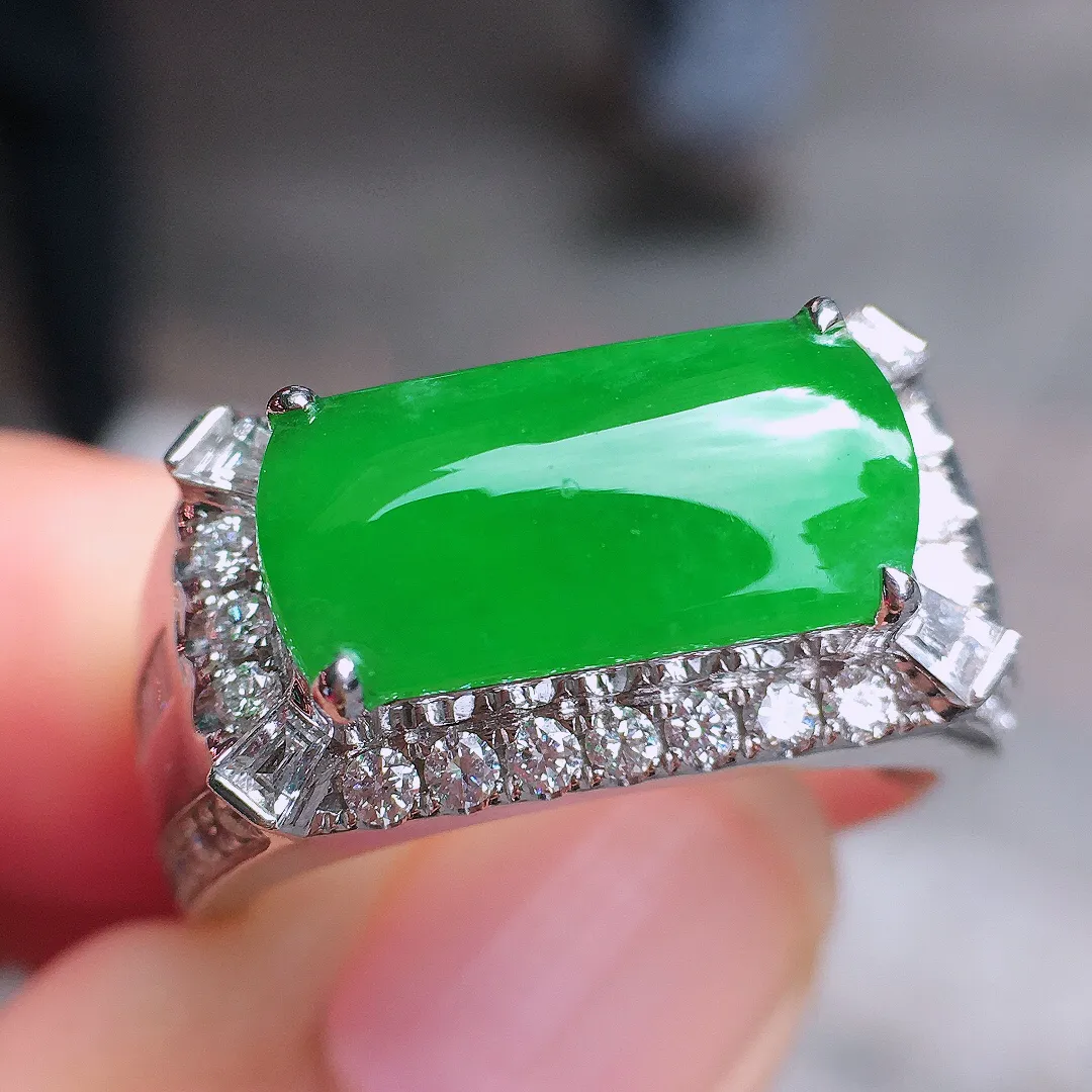 阳绿马鞍戒指，色泽均匀艳丽，玉质细腻，荧光感超
强，饱满圆润，尽显优雅气质，18k
金豪华镶嵌