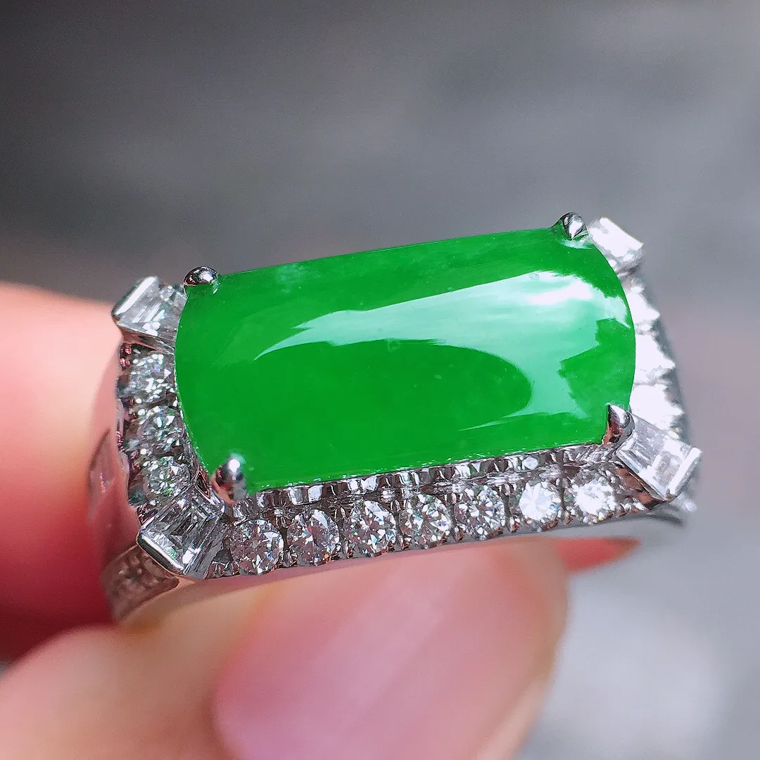 阳绿马鞍戒指，色泽均匀艳丽，玉质细腻，荧光感超
强，饱满圆润，尽显优雅气质，18k
金豪华镶嵌
