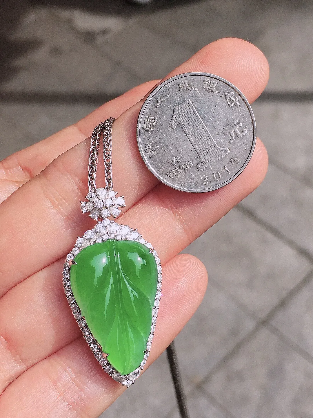 阳绿玉叶吊坠，色泽均匀艳丽，玉质细腻，荧光感超
强，饱满圆润，尽显优雅气质，18k
金豪华镶嵌