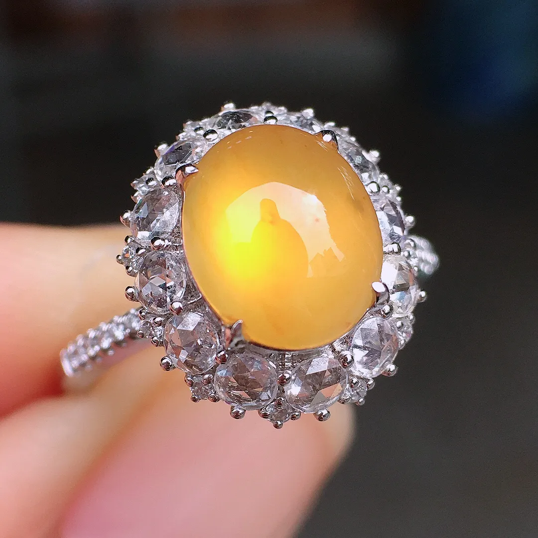 黄翡蛋面戒指，色泽均匀艳丽，玉质细腻，荧光感超
强，饱满圆润，尽显优雅气质，18k
金豪华镶嵌