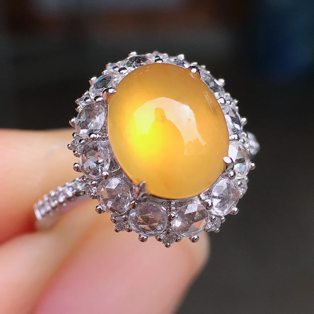 黄翡蛋面戒指，色泽均匀艳丽，玉质细腻，荧光感超
强，饱满圆润，尽显优雅气质，18k
金豪华镶嵌