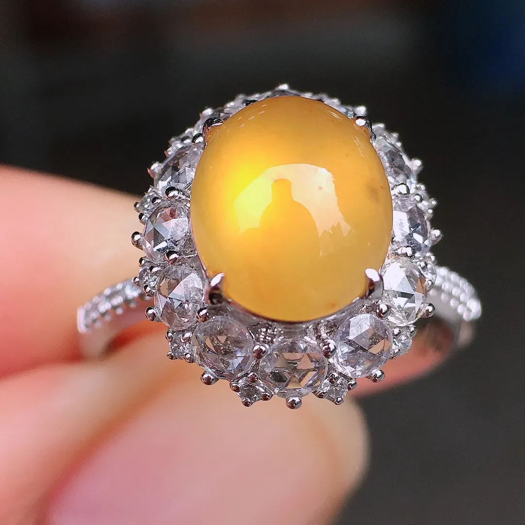 黄翡蛋面戒指，色泽均匀艳丽，玉质细腻，荧光感超
强，饱满圆润，尽显优雅气质，18k
金豪华镶嵌