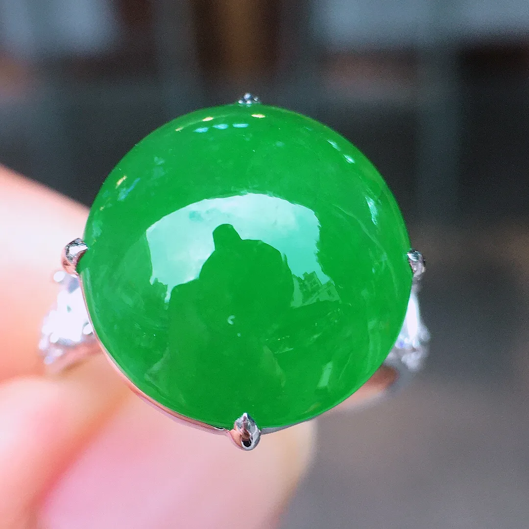 阳绿蛋面戒指，色泽均匀艳丽，玉质细腻，荧光感超
强，饱满圆润，尽显优雅气质，18k
金豪华镶嵌