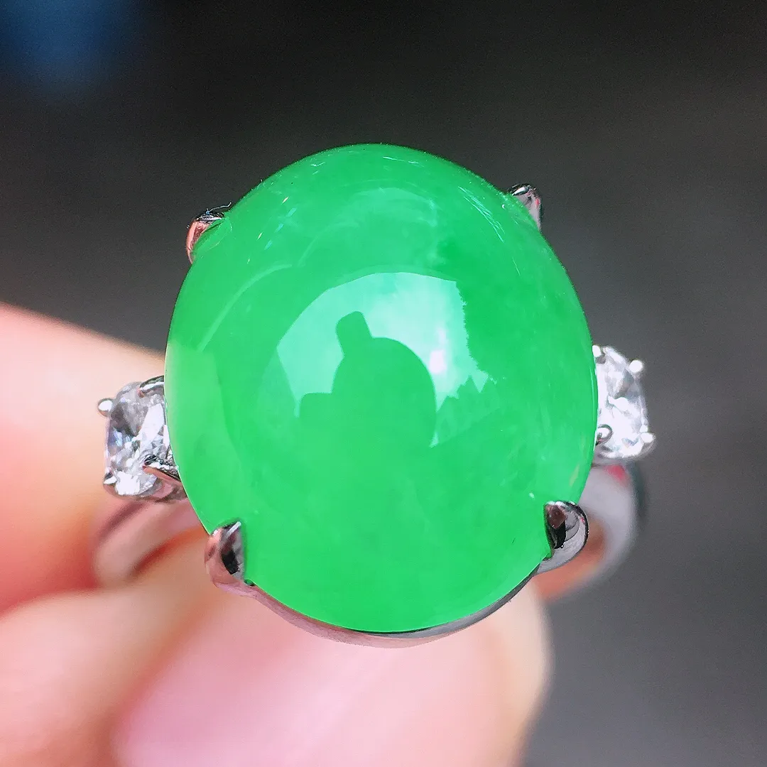 阳绿蛋面戒指，色泽均匀艳丽，玉质细腻，荧光感超
强，饱满圆润，尽显优雅气质，18k
金豪华镶嵌