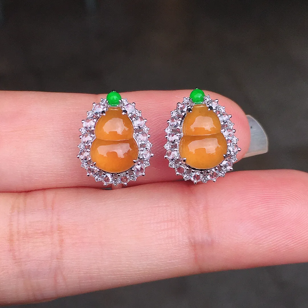 黄翡葫芦耳钉，色泽均匀艳丽，玉质细腻，荧光感超
强，饱满圆润，尽显优雅气质，18k
金豪华镶嵌