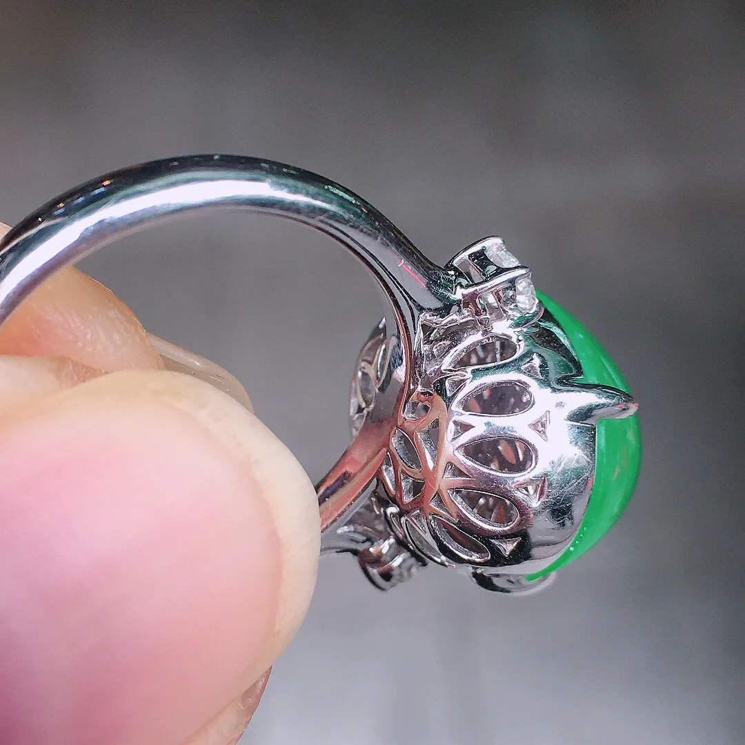 阳绿蛋面戒指，色泽均匀艳丽，玉质细腻，荧光感超
强，饱满圆润，尽显优雅气质，18k
金豪华镶嵌