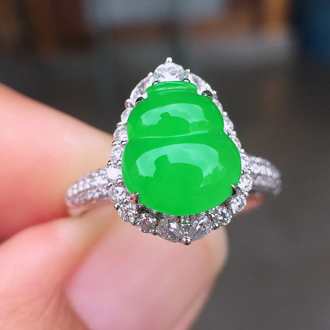 阳绿葫芦戒指，色泽均匀艳丽，玉质细腻，荧光感超
强，饱满圆润，尽显优雅气质，18k
金豪华镶嵌