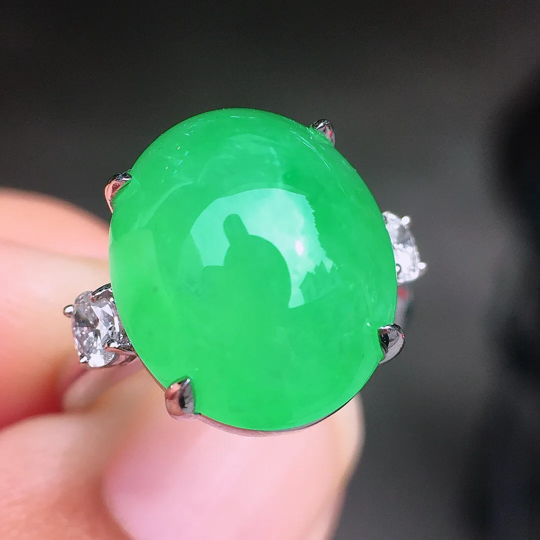 阳绿蛋面戒指，色泽均匀艳丽，玉质细腻，荧光感超
强，饱满圆润，尽显优雅气质，18k
金豪华镶嵌