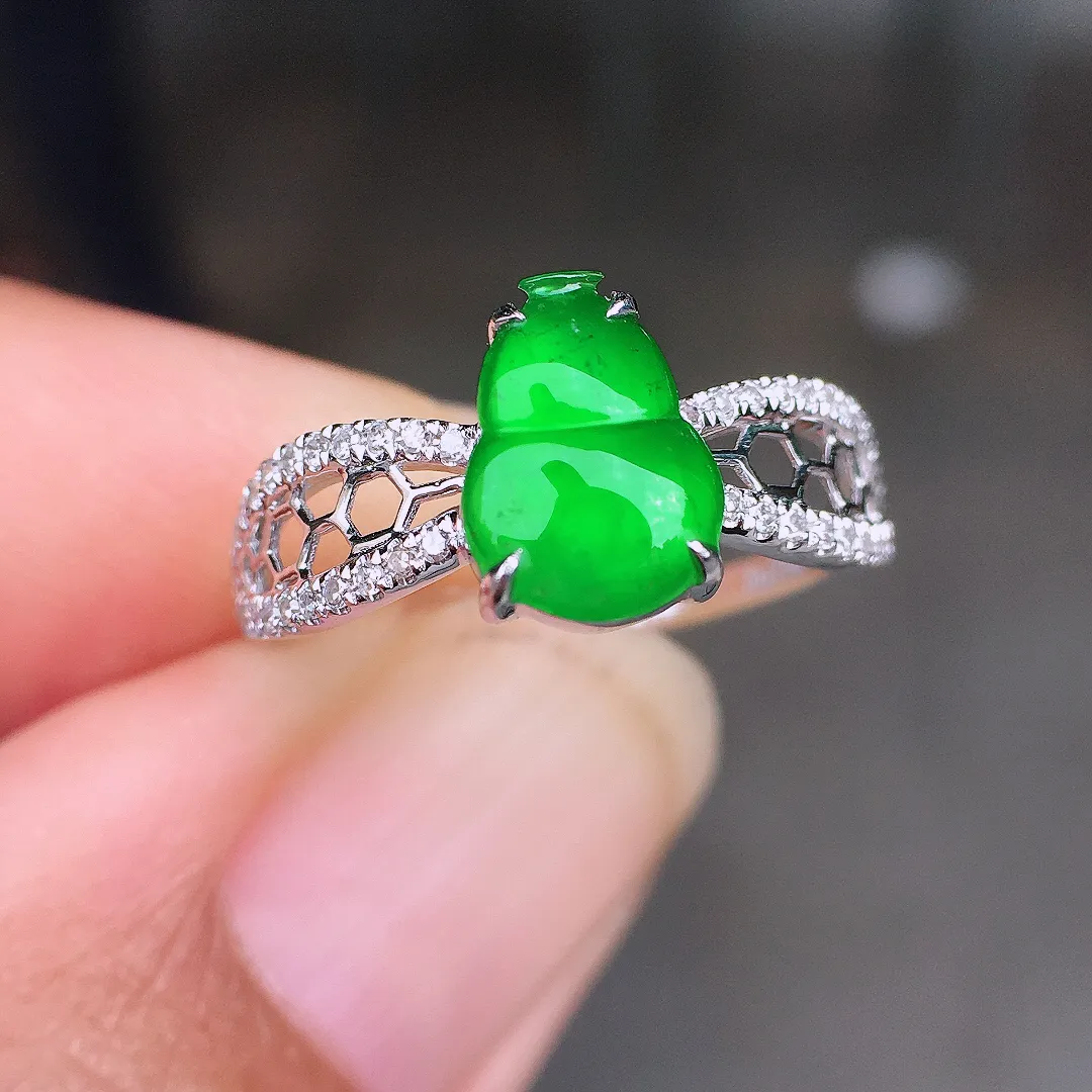 阳绿葫芦戒指，色泽均匀艳丽，玉质细腻，荧光感超
强，饱满圆润，尽显优雅气质，18k
金豪华镶嵌