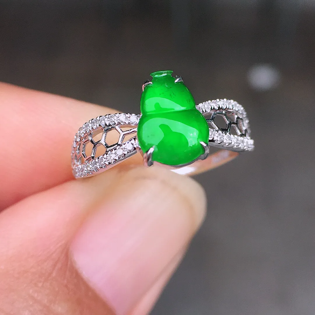 阳绿葫芦戒指，色泽均匀艳丽，玉质细腻，荧光感超
强，饱满圆润，尽显优雅气质，18k
金豪华镶嵌