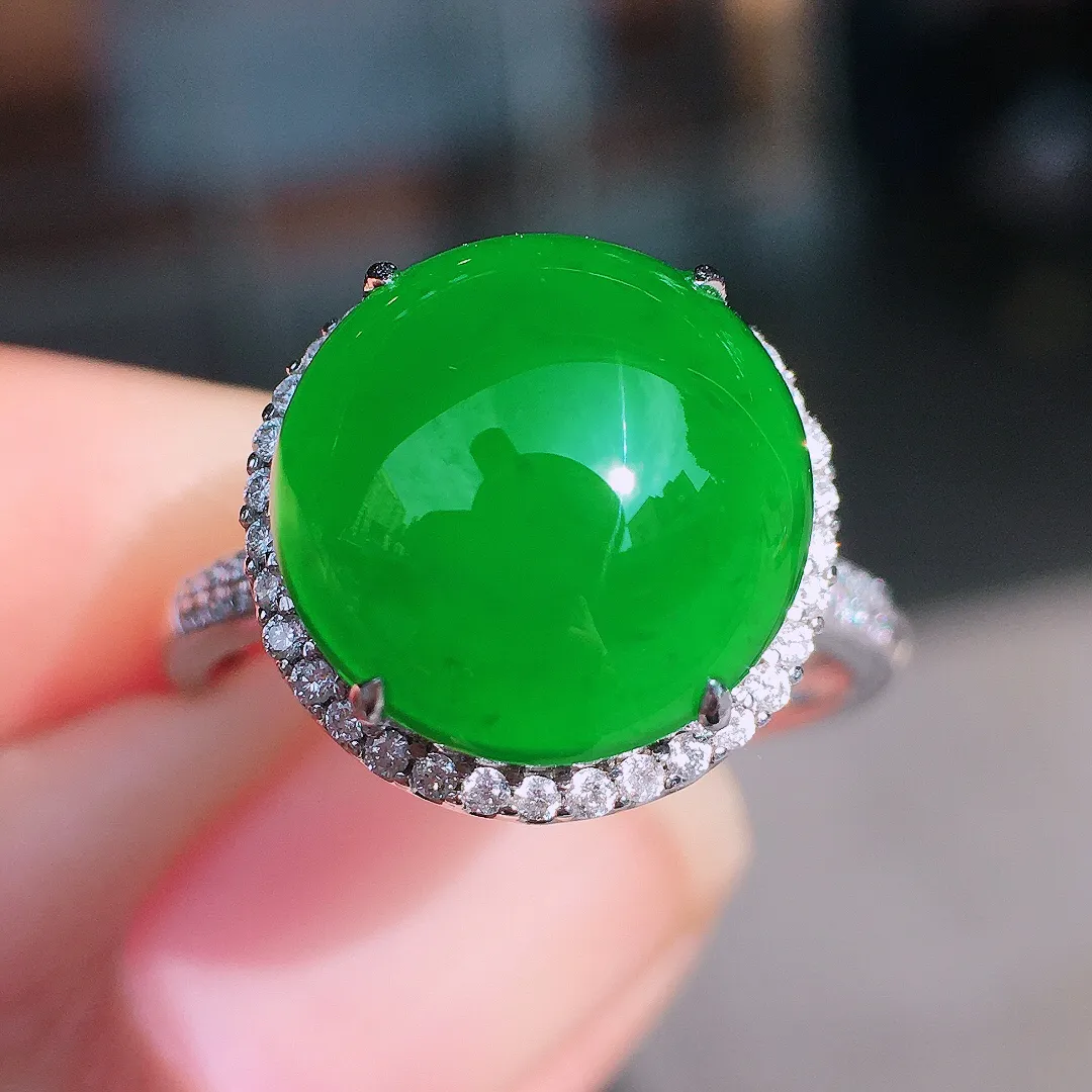 阳绿蛋面戒指，色泽均匀艳丽，玉质细腻，荧光感超
强，饱满圆润，尽显优雅气质，18k
金豪华镶嵌
