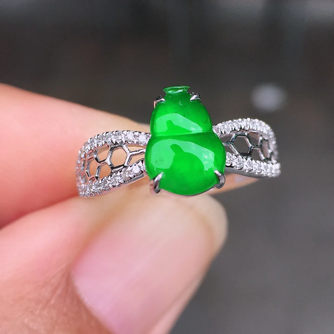 阳绿葫芦戒指，色泽均匀艳丽，玉质细腻，荧光感超
强，饱满圆润，尽显优雅气质，18k
金豪华镶嵌