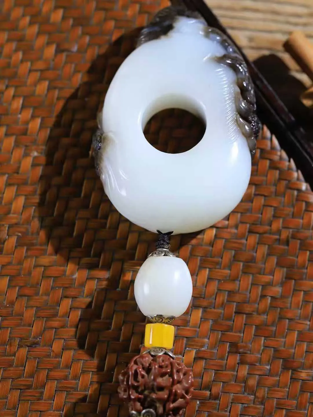 （莲年有余.扳指）

精品和田玉白玉带皮连年有余扳指，质地温润滋腻，手感上佳，精雕莲花，细致入微，线条柔和自然。池清疑水浅,莲动知鱼散，细作清幽莲花，日月散淡，极具灵气，画面和谐美好，寓意一品清廉，连年有余。
重97.8克   尺寸17.8-19.2-29.5mm   451063100A