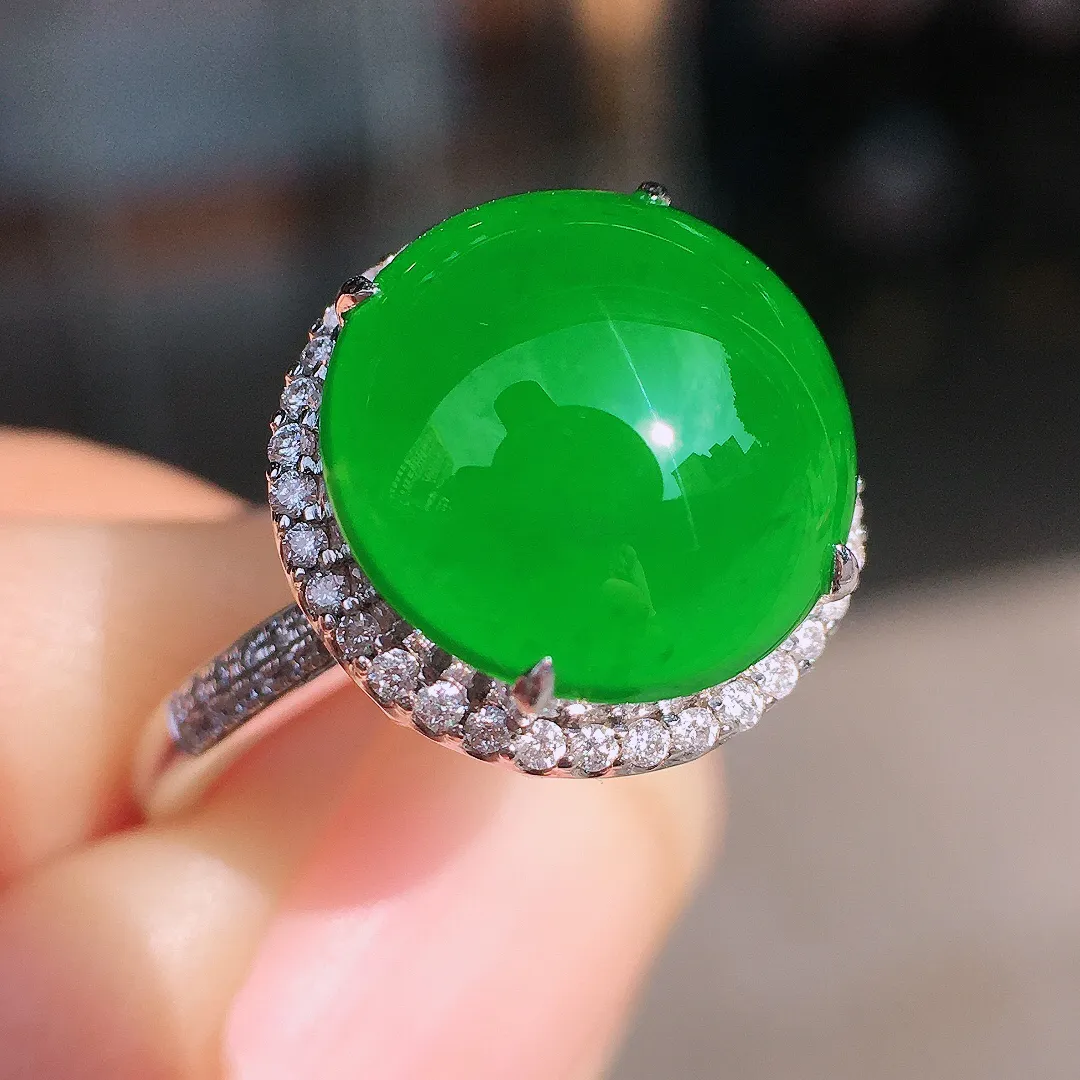 阳绿蛋面戒指，色泽均匀艳丽，玉质细腻，荧光感超
强，饱满圆润，尽显优雅气质，18k
金豪华镶嵌