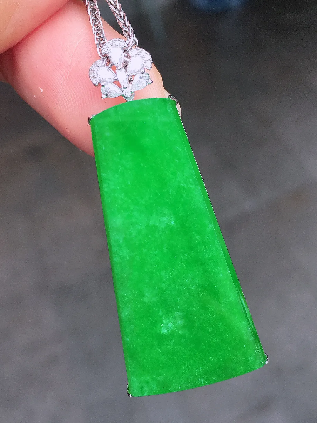 阳绿无事牌吊坠，色泽均匀艳丽，玉质细腻，荧光感超
强，饱满圆润，尽显优雅气质，18k
金豪华镶嵌