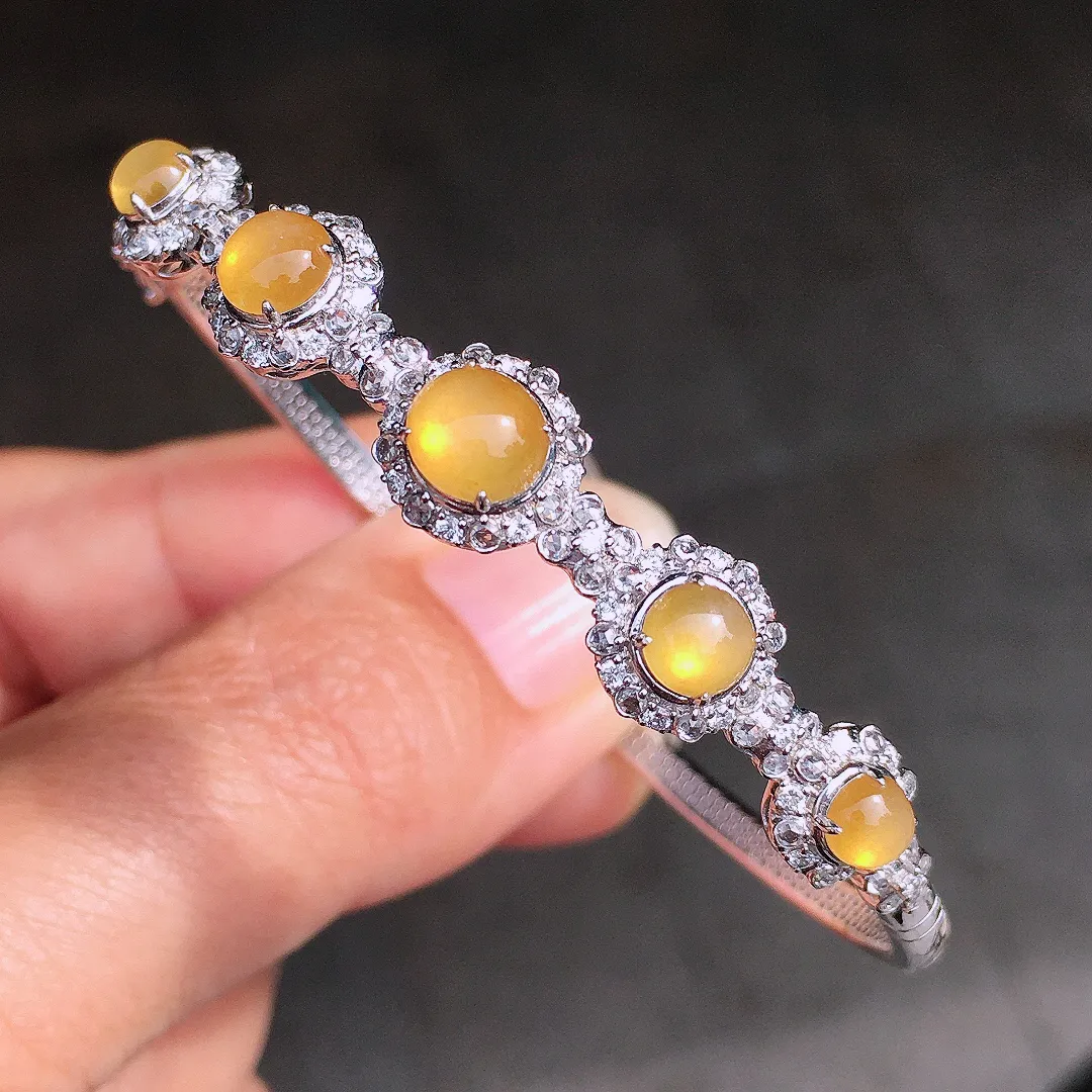 黄翡蛋面手镯，色泽均匀艳丽，玉质细腻，荧光感超
强，饱满圆润，尽显优雅气质，18k
金豪华镶嵌