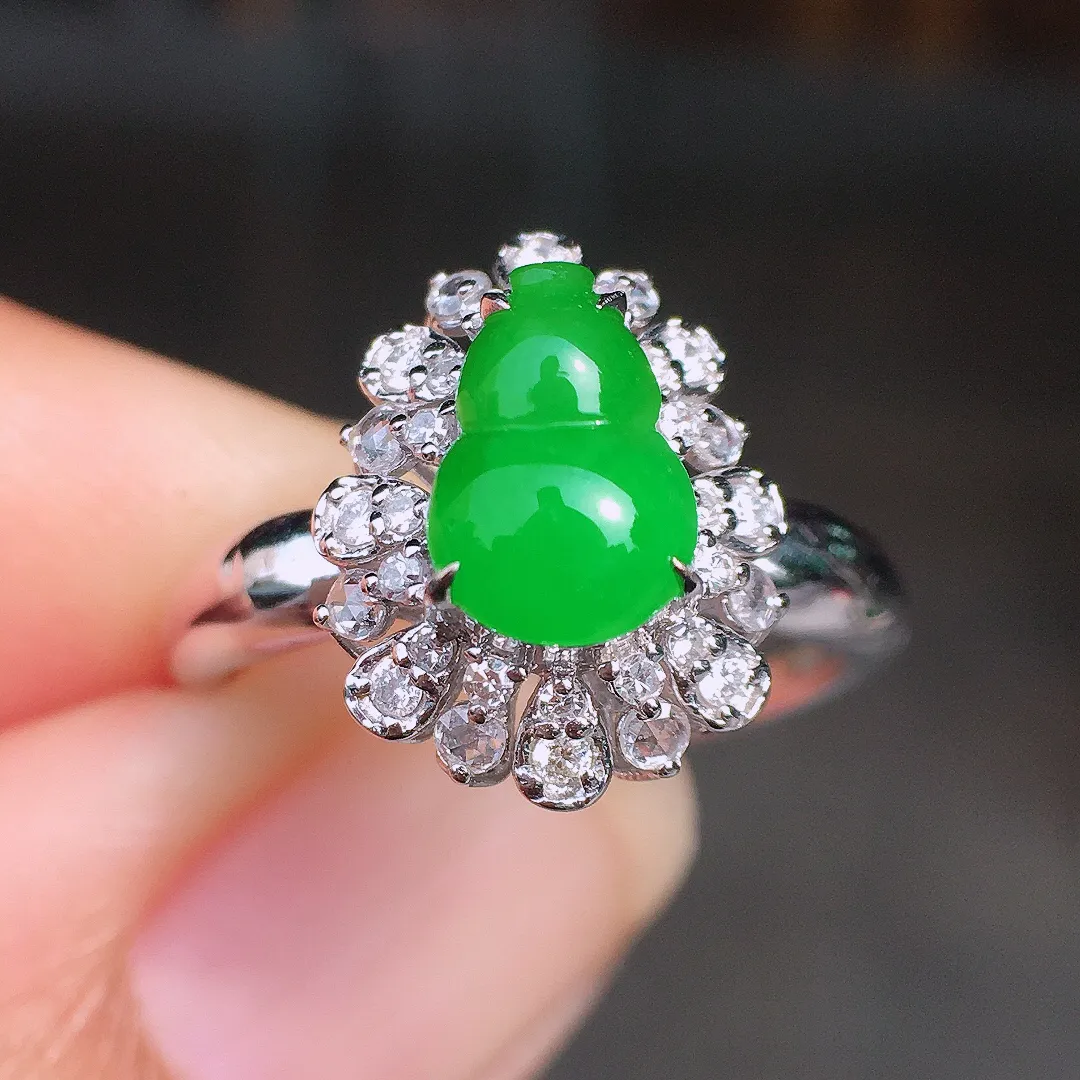 阳绿葫芦戒指，色泽均匀艳丽，玉质细腻，荧光感超
强，饱满圆润，尽显优雅气质，18k
金豪华镶嵌