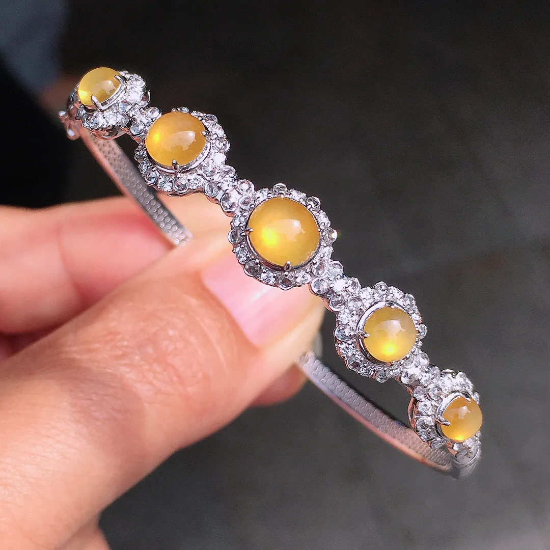 黄翡蛋面手镯，色泽均匀艳丽，玉质细腻，荧光感超
强，饱满圆润，尽显优雅气质，18k
金豪华镶嵌