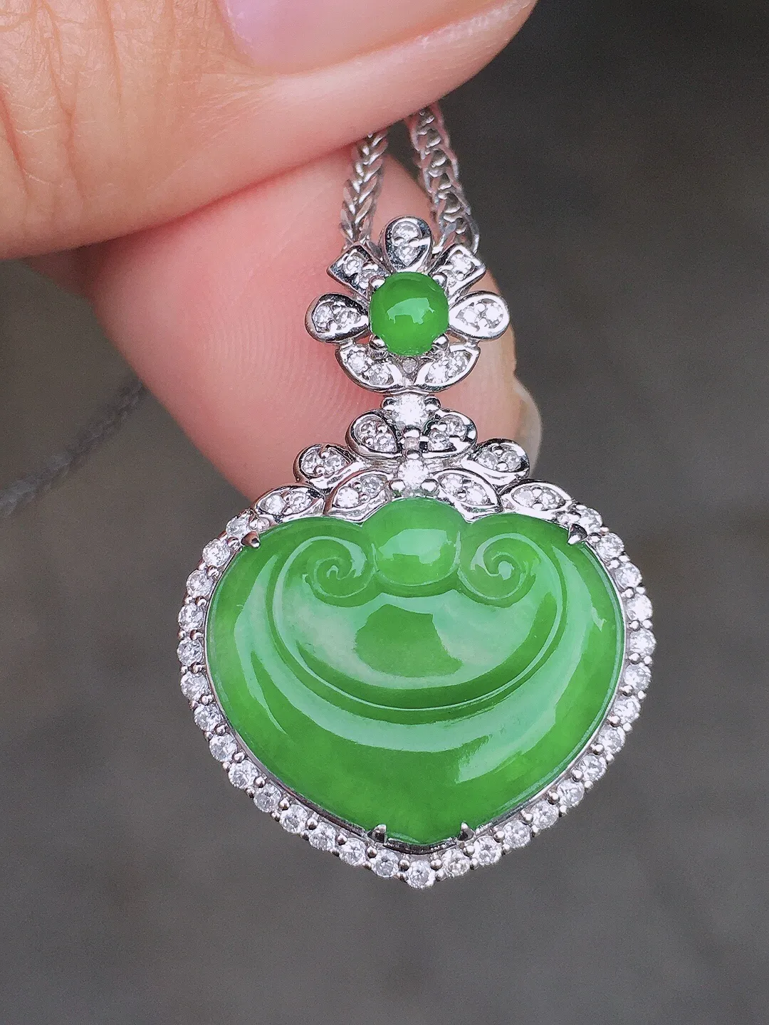 阳绿如意吊坠，色泽均匀艳丽，玉质细腻，荧光感超
强，饱满圆润，尽显优雅气质，18k
金豪华镶嵌