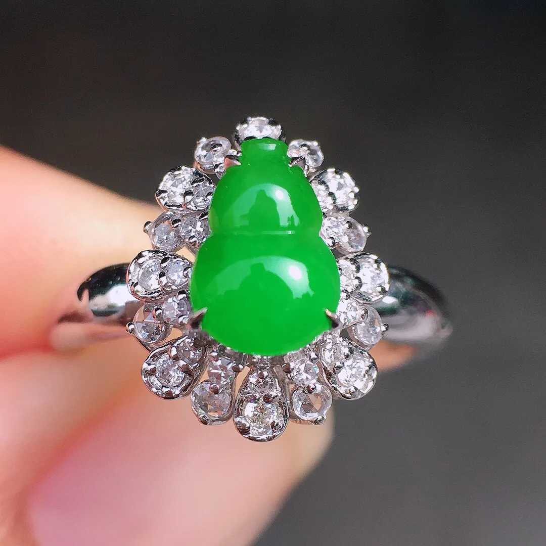 阳绿葫芦戒指，色泽均匀艳丽，玉质细腻，荧光感超
强，饱满圆润，尽显优雅气质，18k
金豪华镶嵌