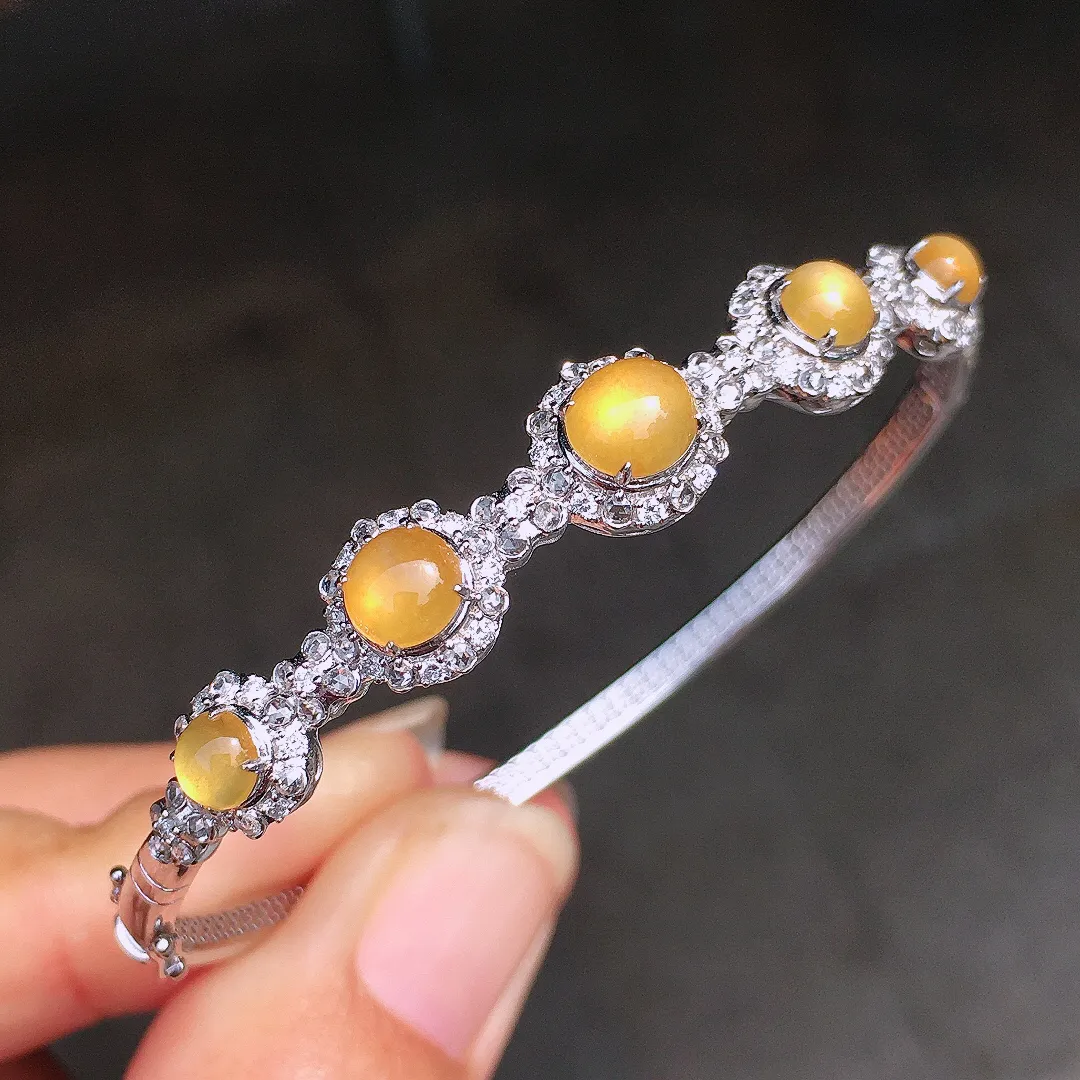 黄翡蛋面手镯，色泽均匀艳丽，玉质细腻，荧光感超
强，饱满圆润，尽显优雅气质，18k
金豪华镶嵌