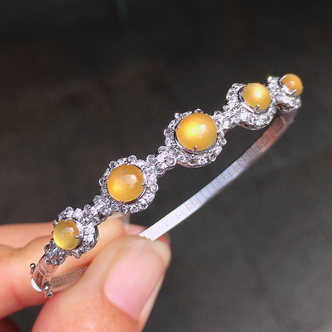 黄翡蛋面手镯，色泽均匀艳丽，玉质细腻，荧光感超
强，饱满圆润，尽显优雅气质，18k
金豪华镶嵌